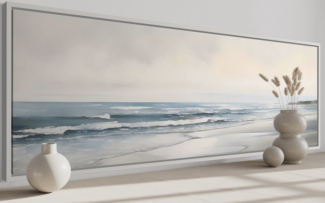 Long horizontal framed canvas wall art featuring a minimalist coastal beach scene in soft tones.