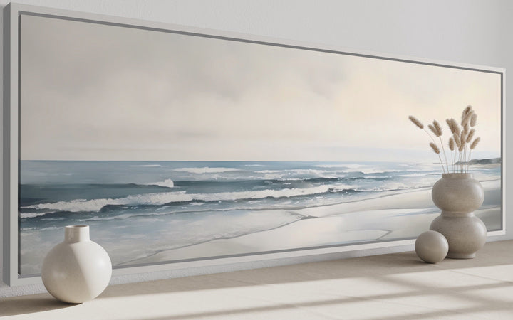 Long horizontal framed canvas wall art featuring a minimalist coastal beach scene in soft tones.