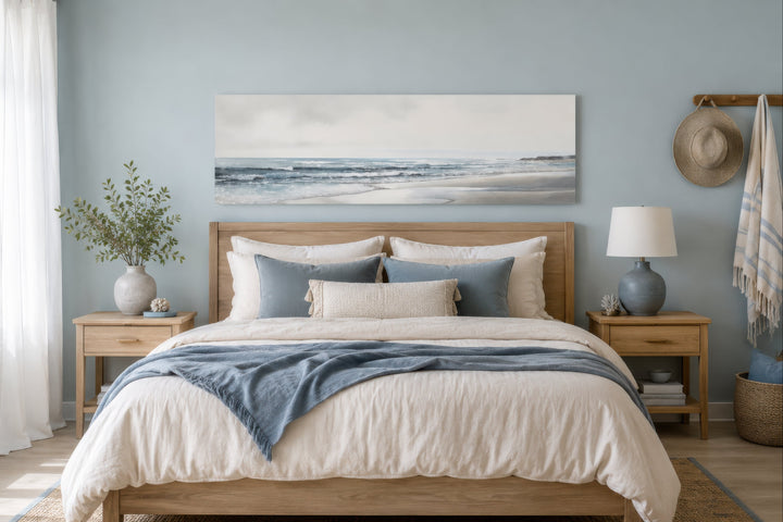 Long horizontal coastal framed canvas wall art featuring a minimalist beach scene above a bed.