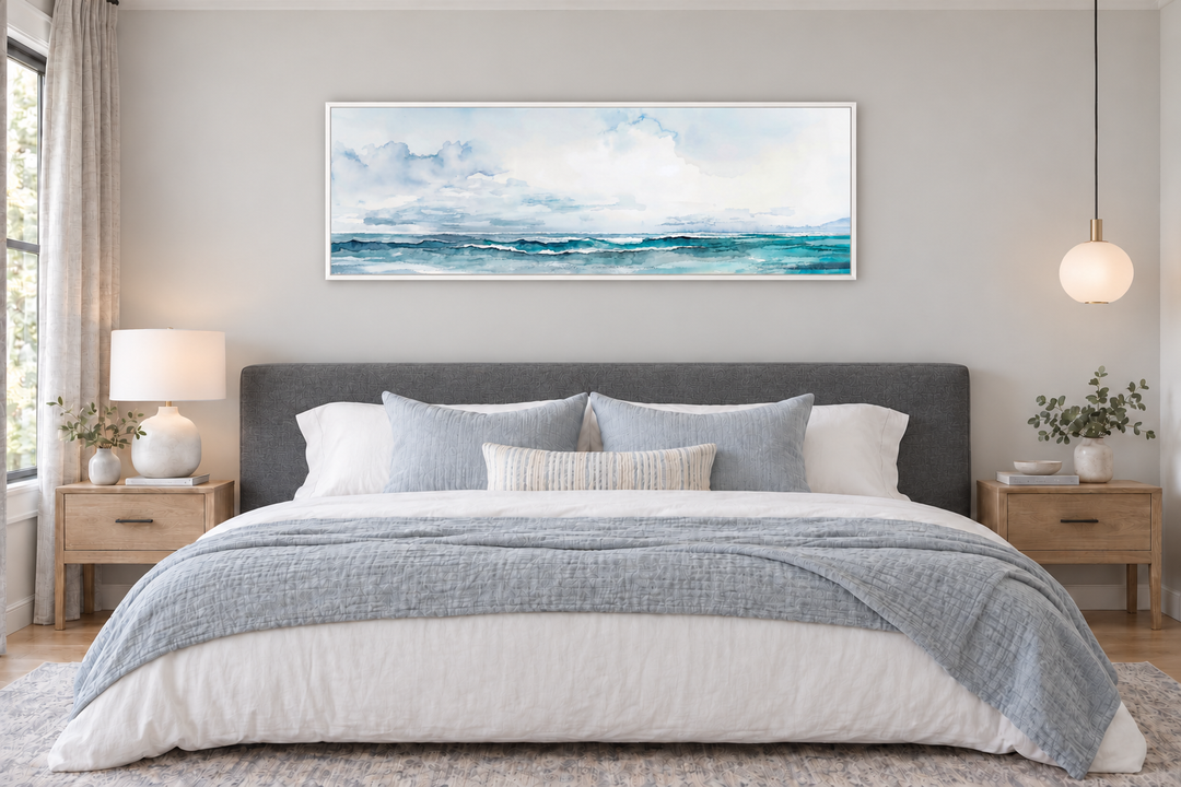 Minimalist ocean blue gray horizontal framed canvas wall art hanging over a bed in a bedroom.