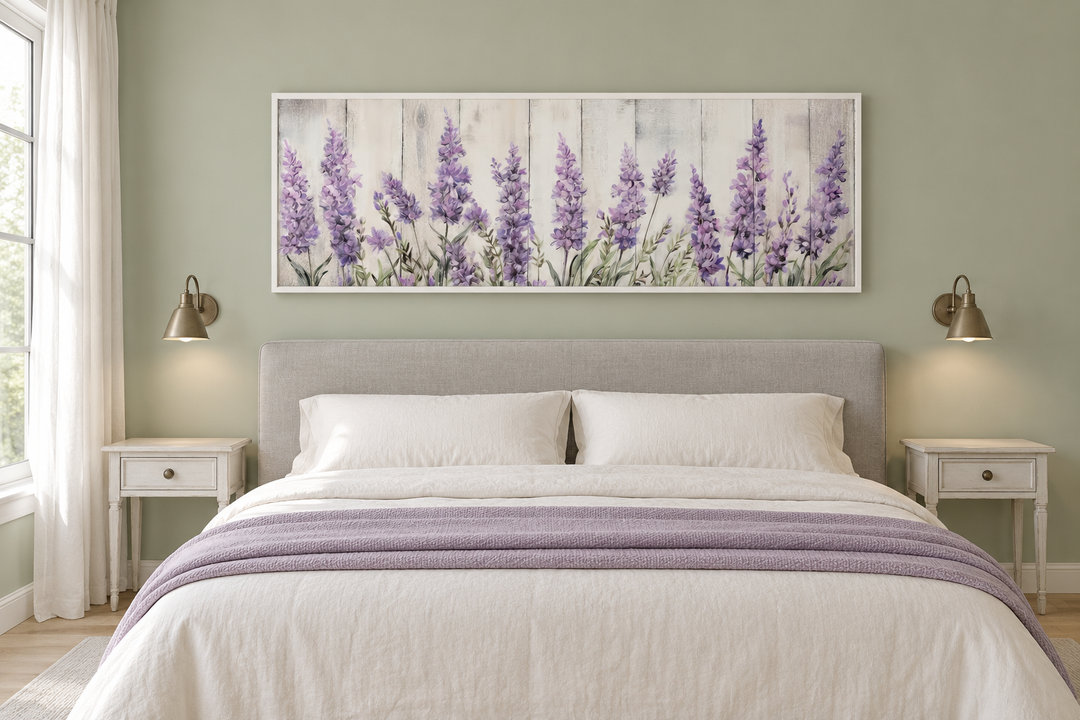 Horizontal framed canvas wall art of purple lavender wildflowers above a bed in a sage green room.