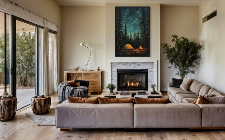 Vertical canvas wall art of a glowing campfire and tent in a starry pine forest above a fireplace.