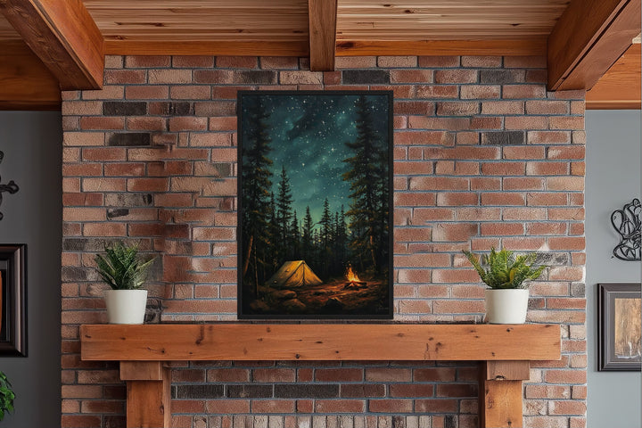 Campfire and tent in a pine forest under a starry night sky, framed wall art on a brick fireplace.