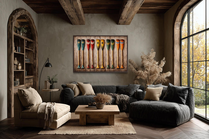 Horizontal canvas print of colorful rustic canoe paddles on a wood plank background in a cozy room.