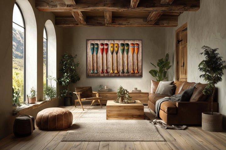 Rustic wooden canoe paddle canvas print displayed in a cozy, earth-toned living room.