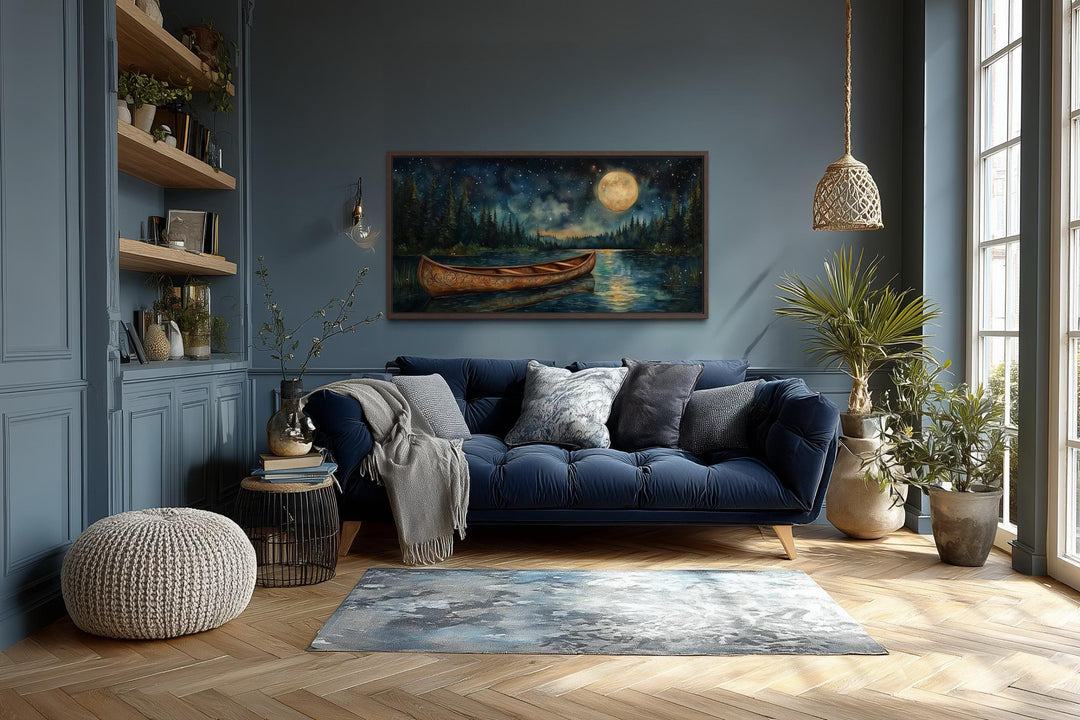 Canoe on moonlit lake and forest night scene canvas wall art hanging in a modern living room.