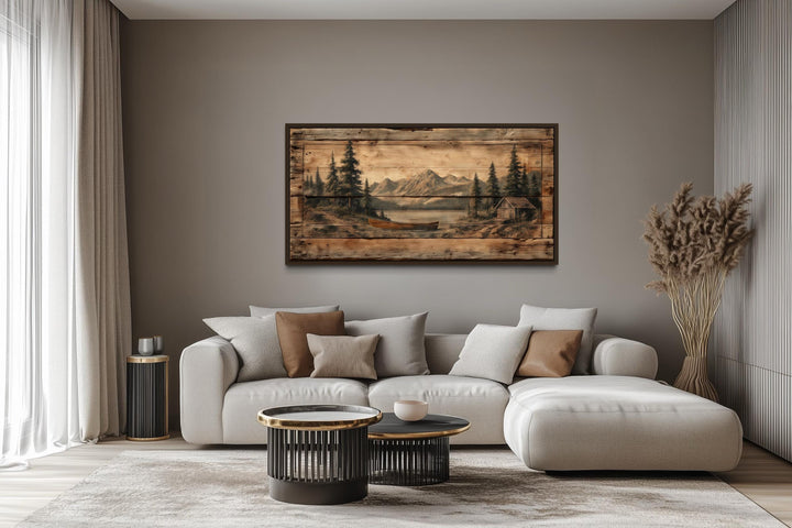Canoe on mountain lake canvas wall art displayed above a modern sofa in a neutral living room.