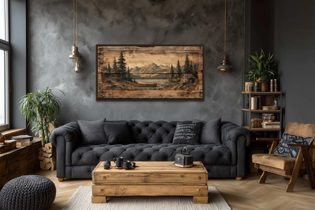 Canoe on mountain lake canvas wall art in a rustic living room with a dark grey sofa.