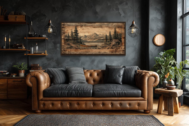 Canoe on Mountain Lake canvas wall art on a dark wall above a brown leather sofa.