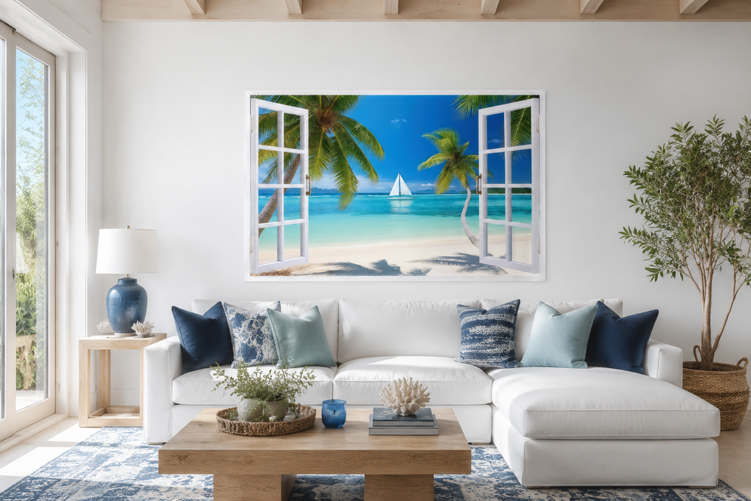 Caribbean beach and sailboat open window view wall art above a white sofa in a coastal living room.