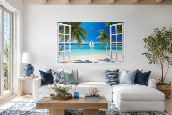 Caribbean beach and sailboat open window view wall art above a white sofa in a coastal living room.