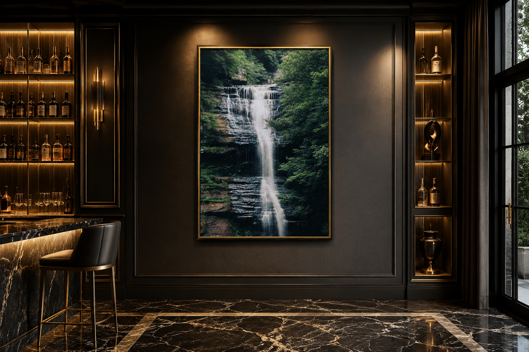Vertical canvas print of a sage green forest waterfall landscape on a dark wall in a modern room.