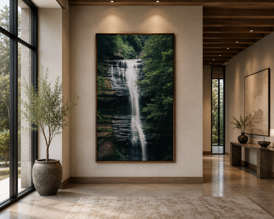 Vertical wall art of a cascading waterfall in a lush sage green forest on a neutral wall.