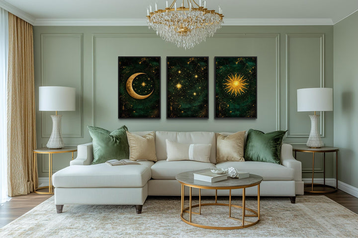 Emerald green and gold triptych canvas prints featuring a sun, moon, and stars above a white sofa.