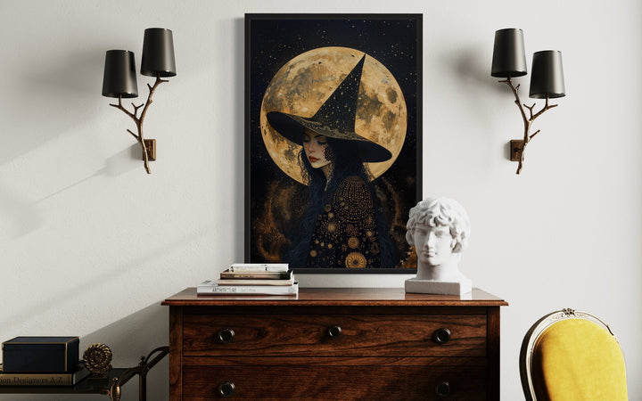 Celestial witch wall art with a full moon and starry sky, framed above a wooden dresser.