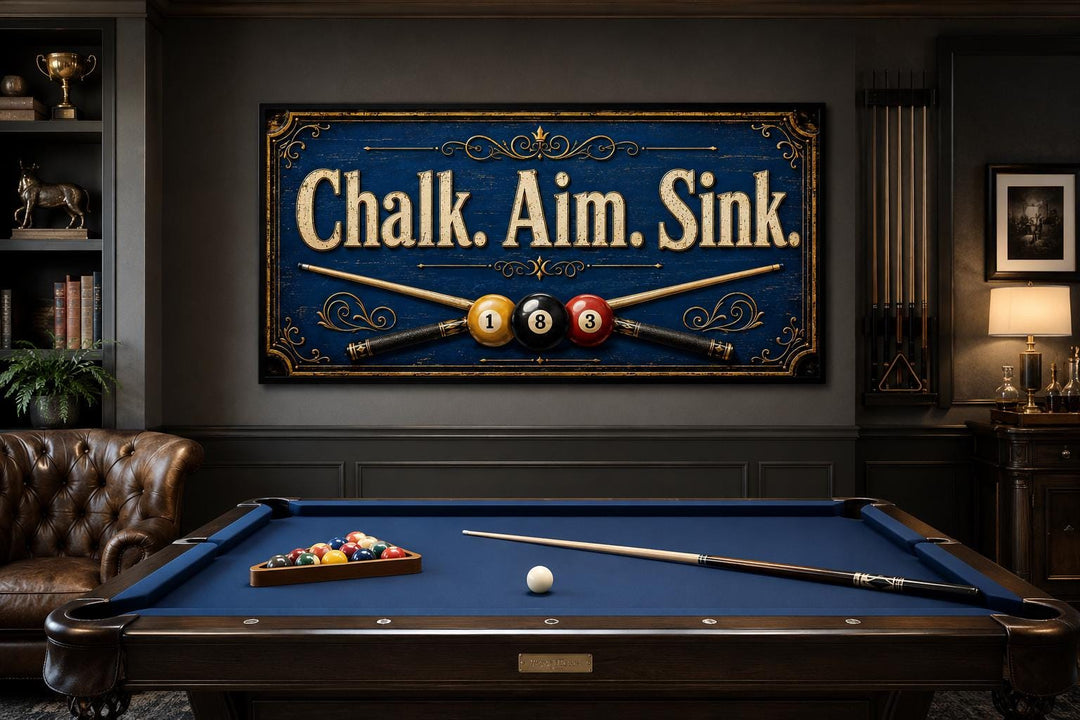 Vintage navy blue billiards sign with gold text 'Chalk. Aim. Sink.' above a pool table.