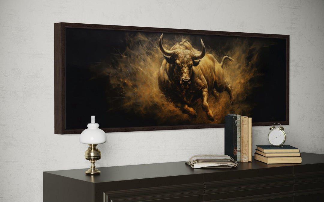 Charging bull horizontal canvas wall art in golden tones above a dark wood dresser.