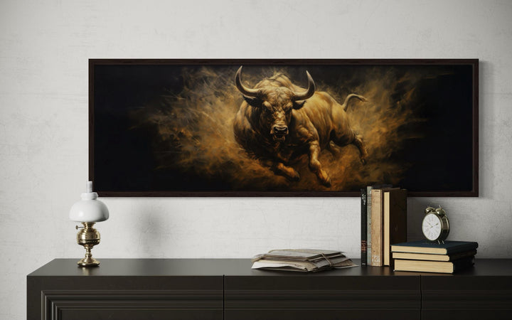 Charging bull horizontal canvas wall art in golden tones on a dark background above a desk.
