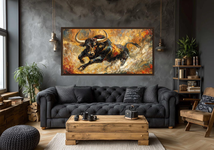 Charging bull canvas print with gold and red abstract background in a modern living room.