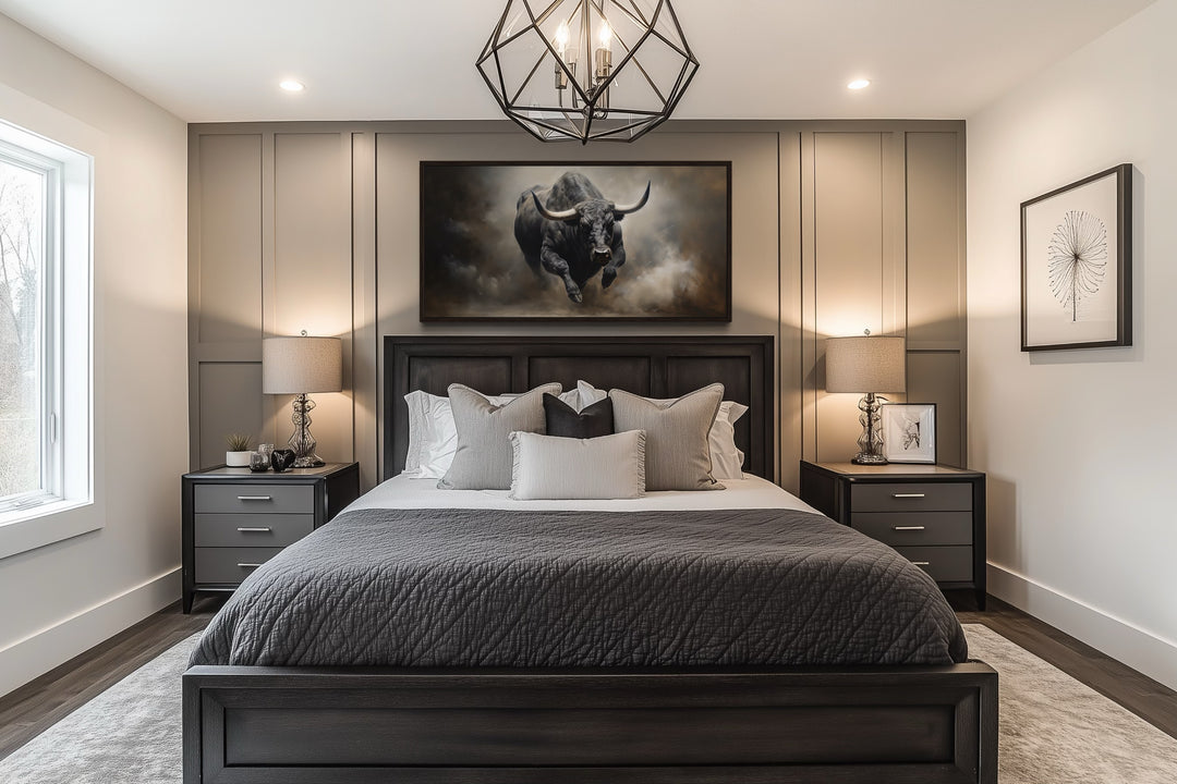 Framed charging bull canvas print hanging above a bed in a modern bedroom with grey paneled walls.
