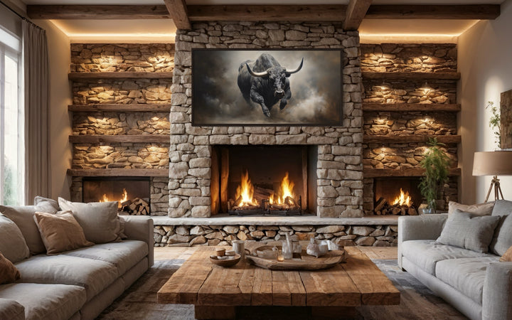 Framed charging bull canvas print mounted on a rustic stone fireplace in a cozy living room.