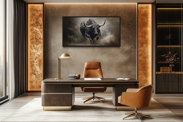 Framed canvas print of a charging bull hanging in a modern office above a dark wood desk.