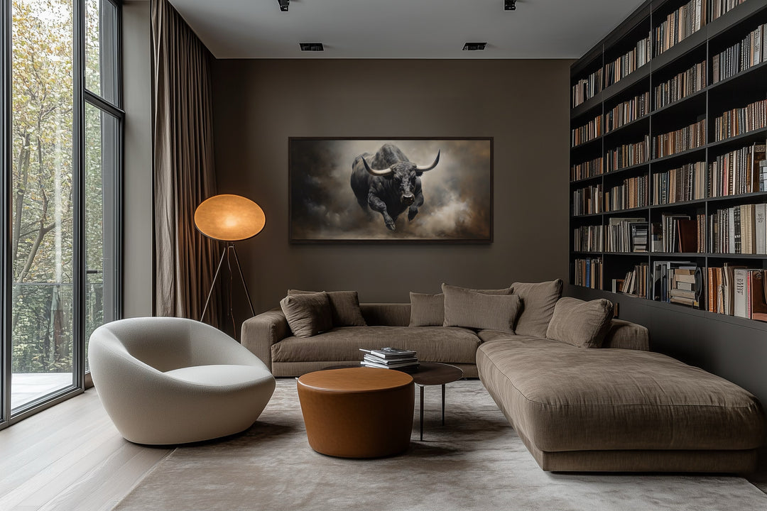 Framed charging bull canvas print on a dark wall in a modern living room with a brown sectional.