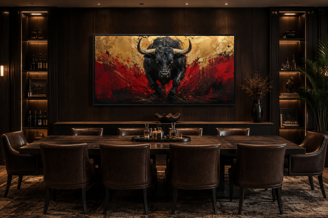 Framed canvas art of a charging black bull with red and gold abstract background in a dark office.