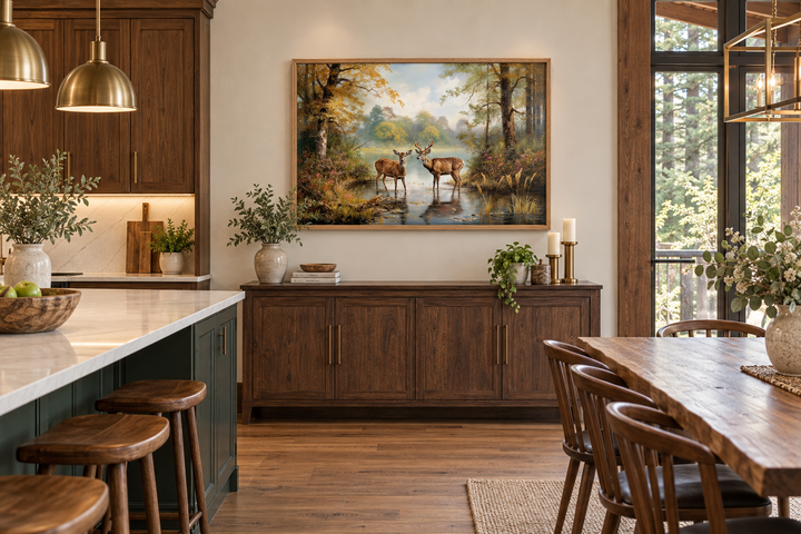 Deer doe and buck in a forest framed canvas wall art hanging above a wooden sideboard in a cabin.