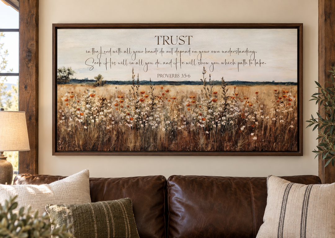 Proverbs 3:5-6 scripture canvas art featuring a golden wildflower field above a brown leather sofa.