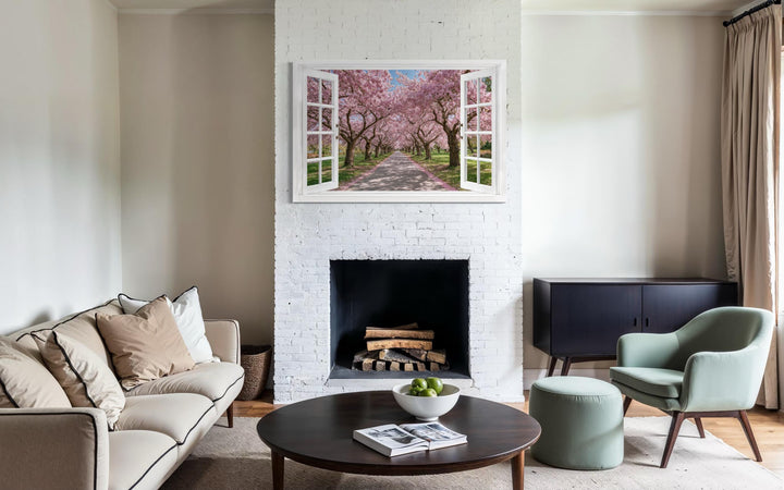Cherry blossom window view wall art featuring pink sakura trees in a white frame over a fireplace.