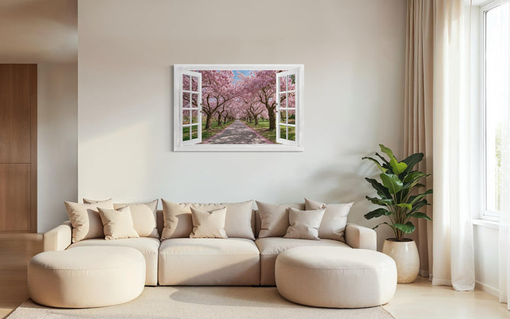 Cherry blossom window view wall art hangs above a beige sectional sofa in a modern living room.