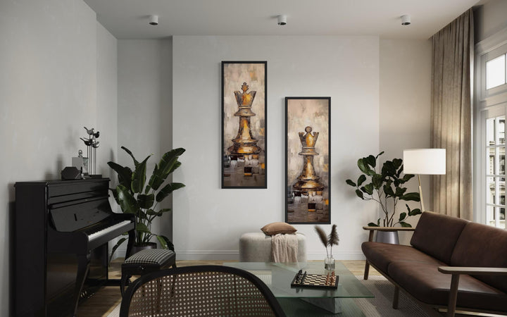 Two tall, narrow canvas prints featuring golden chess king and queen pieces on a white wall.