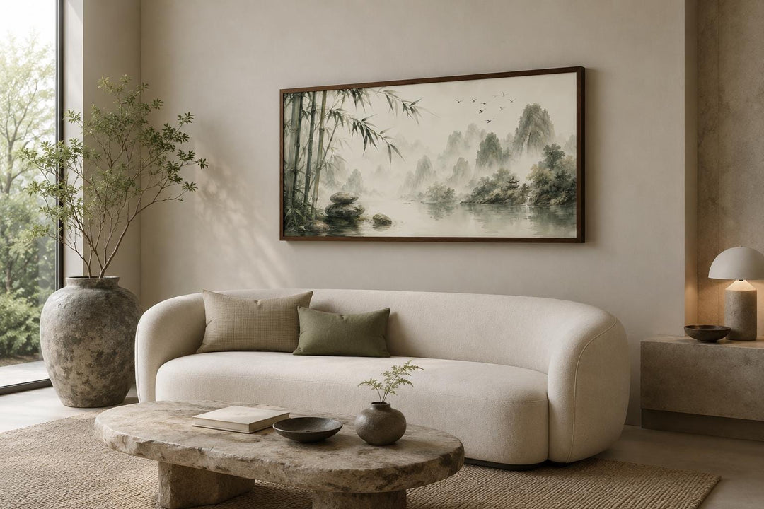 Chinese landscape canvas print of misty mountains and bamboo in sage green and gray above a sofa.