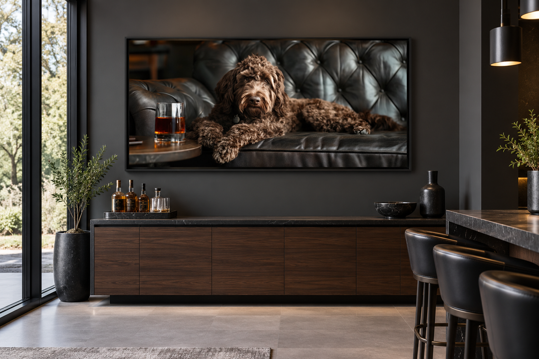 Framed canvas art of a chocolate goldendoodle on a leather couch with a glass of whiskey.