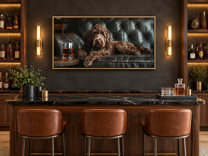 Framed canvas art of a chocolate Goldendoodle on a leather couch with whiskey in a home bar setting.