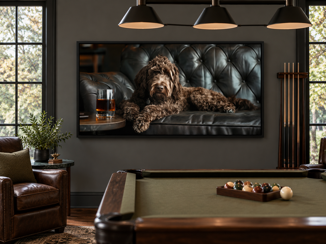 Framed canvas art of a chocolate goldendoodle on a leather couch with whiskey in a billiards room.