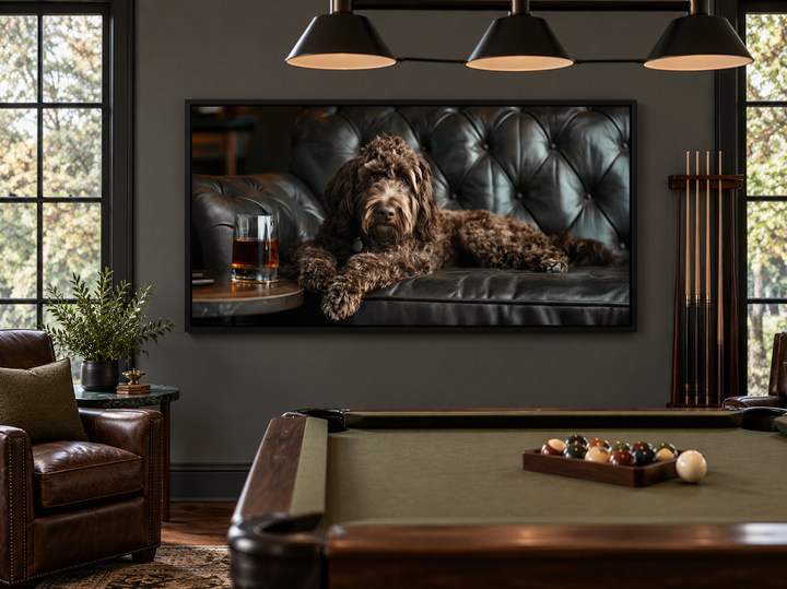 Framed canvas art of a chocolate goldendoodle on a leather couch with whiskey in a billiards room.
