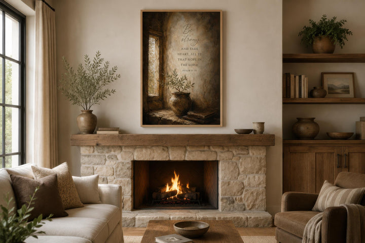 Psalm 31:24 scripture canvas art above a stone fireplace in a warm, rustic living room.
