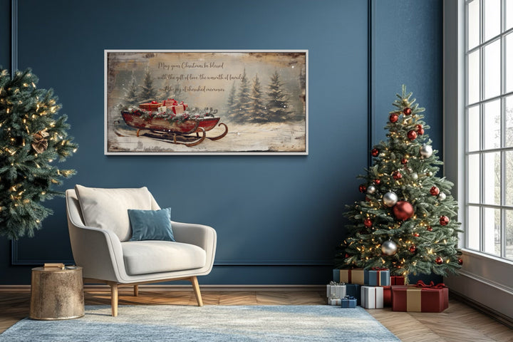 Framed canvas wall art of Santa's sleigh with gifts and a Christmas blessing in a blue living room.