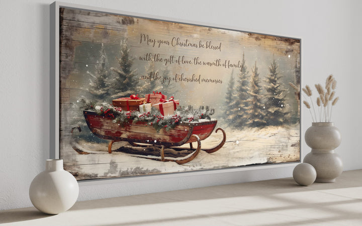 Framed canvas wall art of a rustic red sleigh with gifts and a Christmas blessing message.