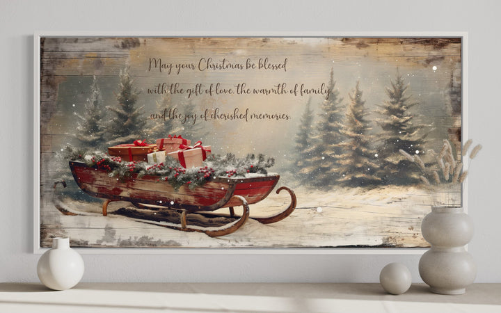 Framed canvas art of a red sleigh with gifts in a snowy forest with a Christmas blessing message.