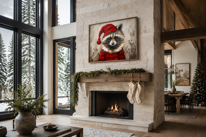 Framed canvas wall art of a raccoon in a Santa hat hanging above a rustic stone fireplace mantel.