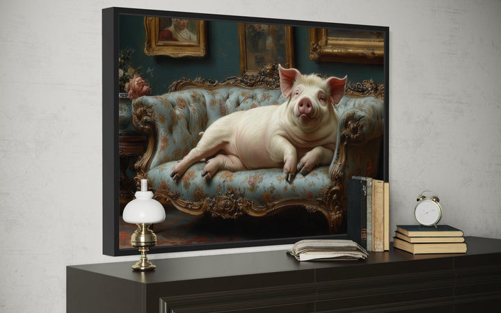 Victorian-style framed canvas art of a chubby pig lounging on a floral tufted couch.