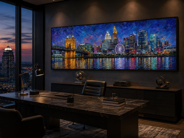 Panoramic canvas print of the Cincinnati skyline at night displayed in a modern dark-toned office.