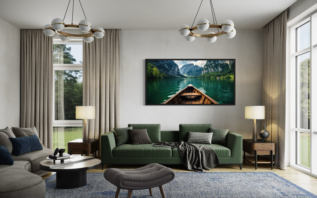 Framed canvas art of a wooden canoe on an emerald green lake hanging above a green sofa.