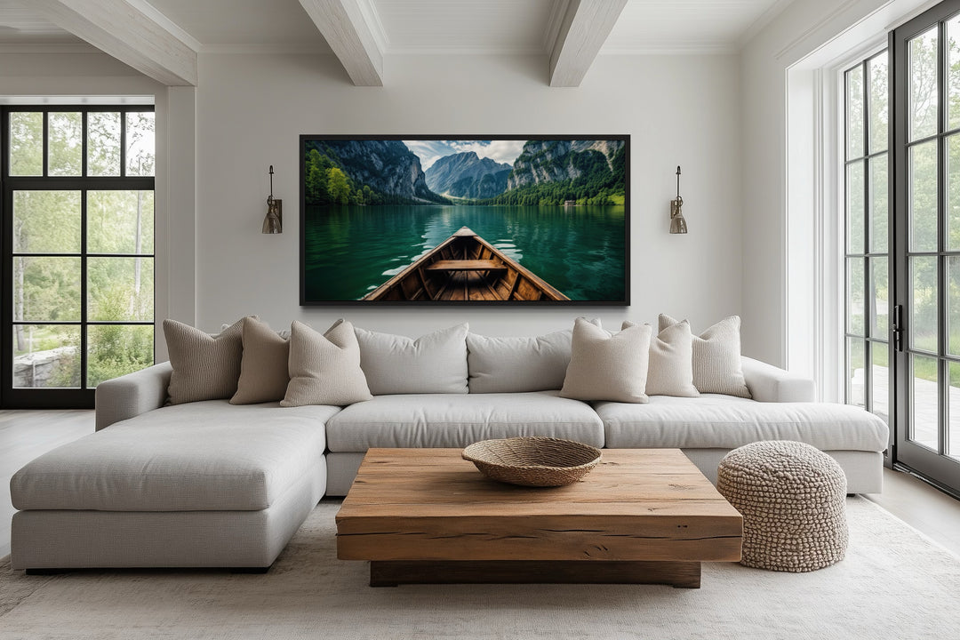 Framed canvas art of a wooden boat on an emerald green lake in a modern living room.