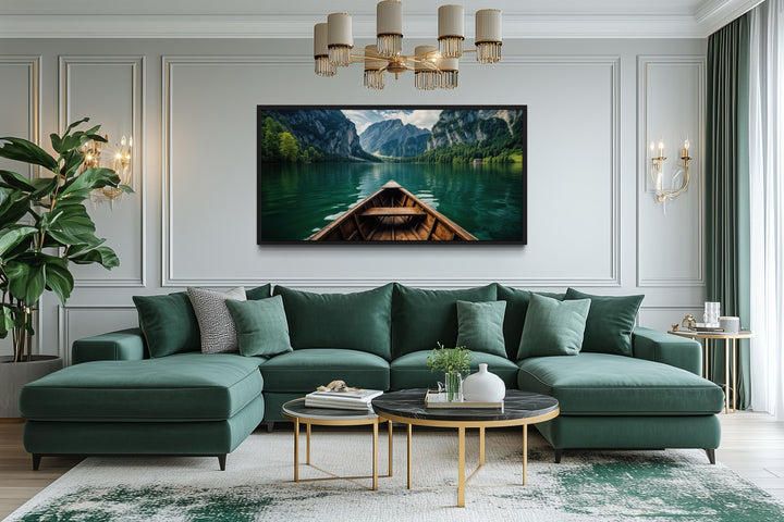 Framed canvas art of a wooden boat on an emerald green lake, hanging above a green sectional sofa.
