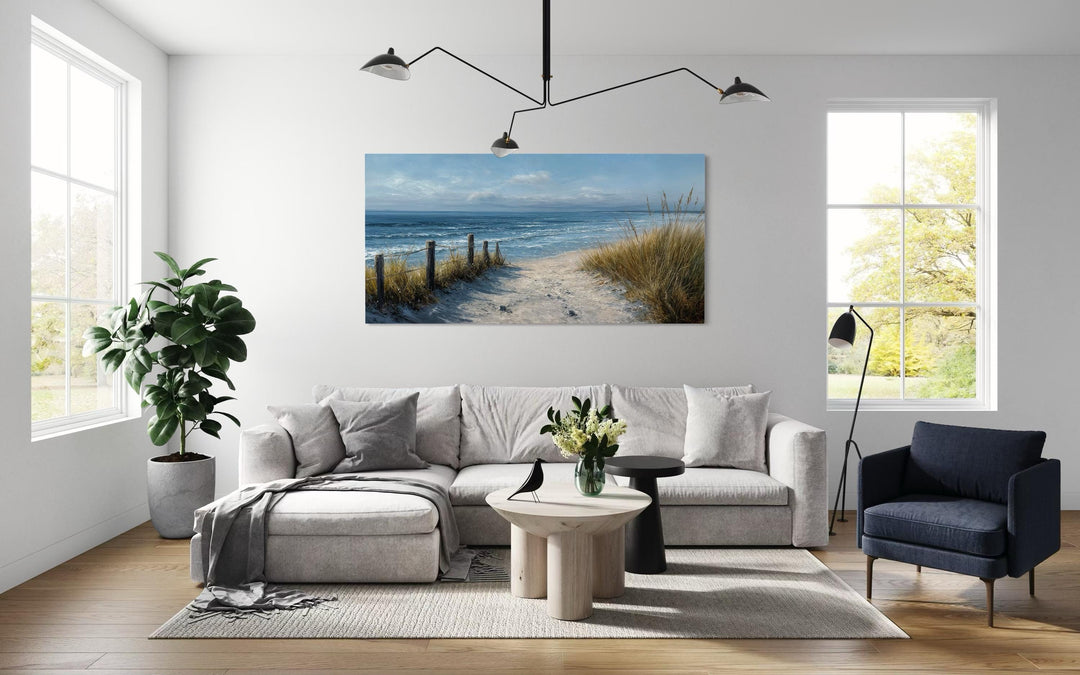 Horizontal coastal beach canvas print featuring a sandy path to the ocean in a modern living room.