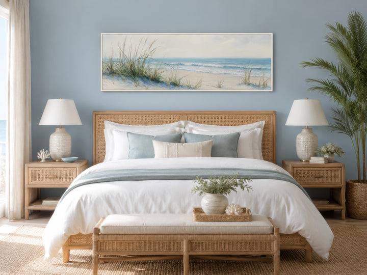 Wide horizontal canvas print of sandy beach dunes and ocean above a coastal-style bed.